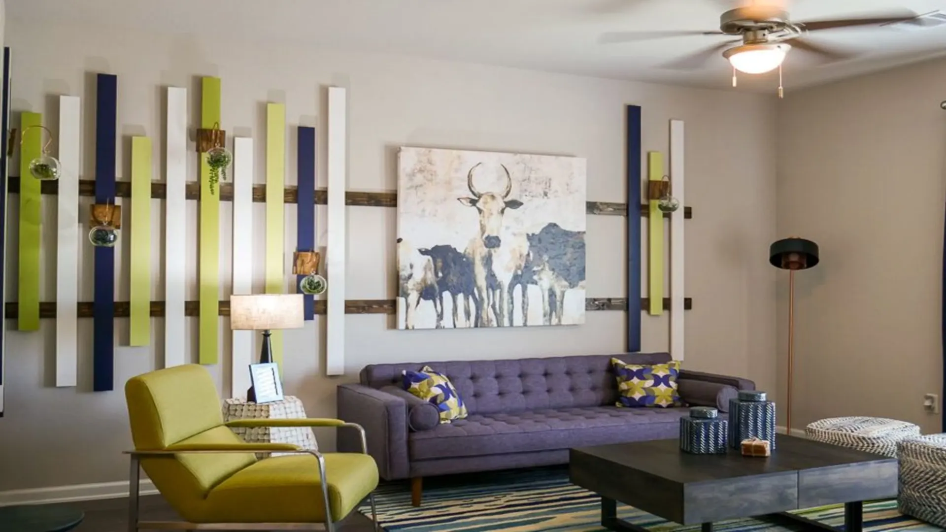 a living room with a purple couch, green chair and blue lamp at The Biltmore at  Park
