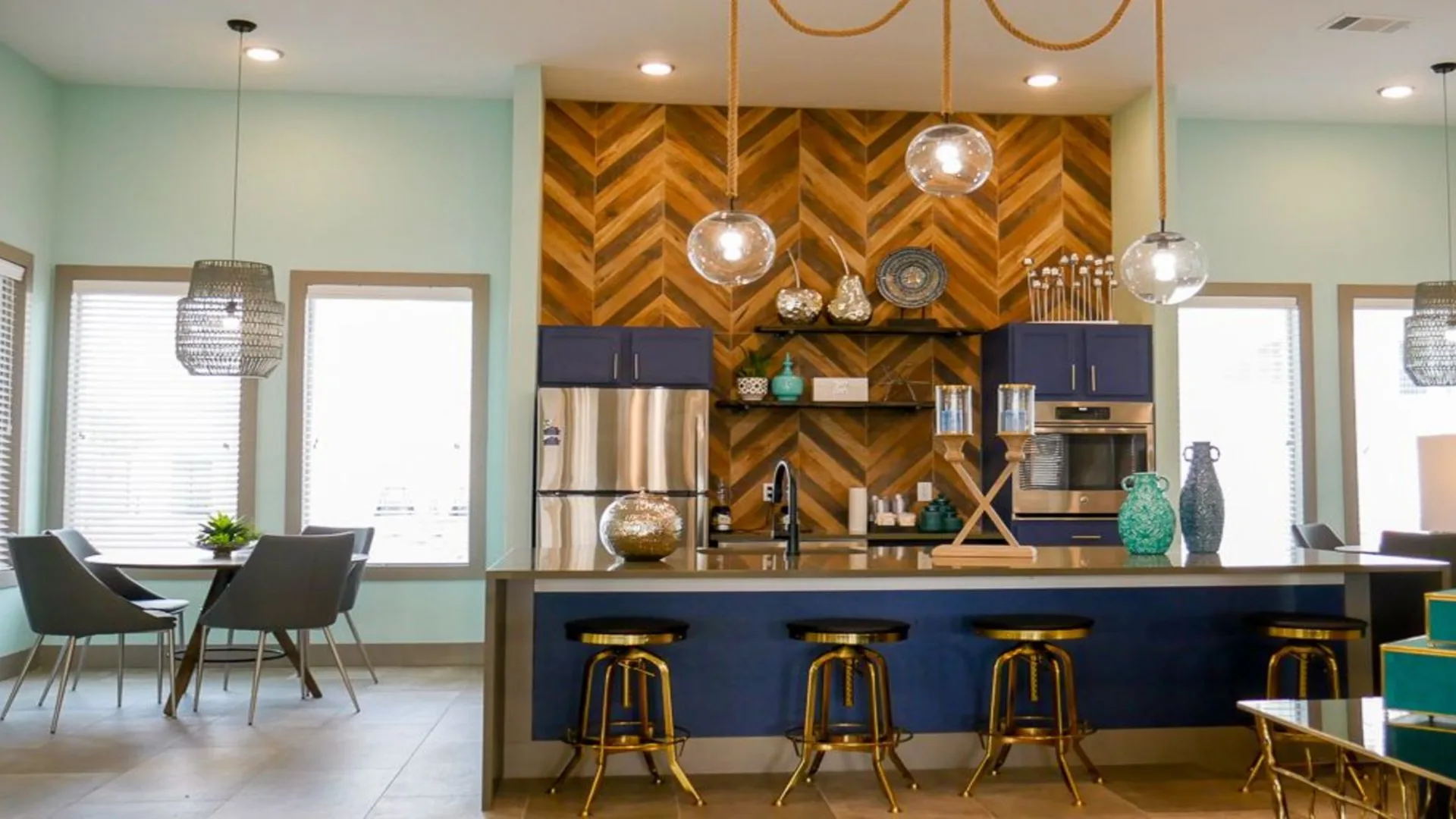 a kitchen with blue cabinets and a chevron patterned wall at The Biltmore at  Park