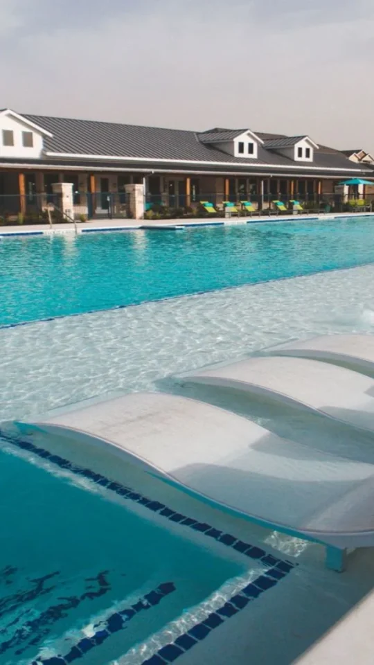 a large pool with lounge chairs and umbrellas at The Biltmore at  Park